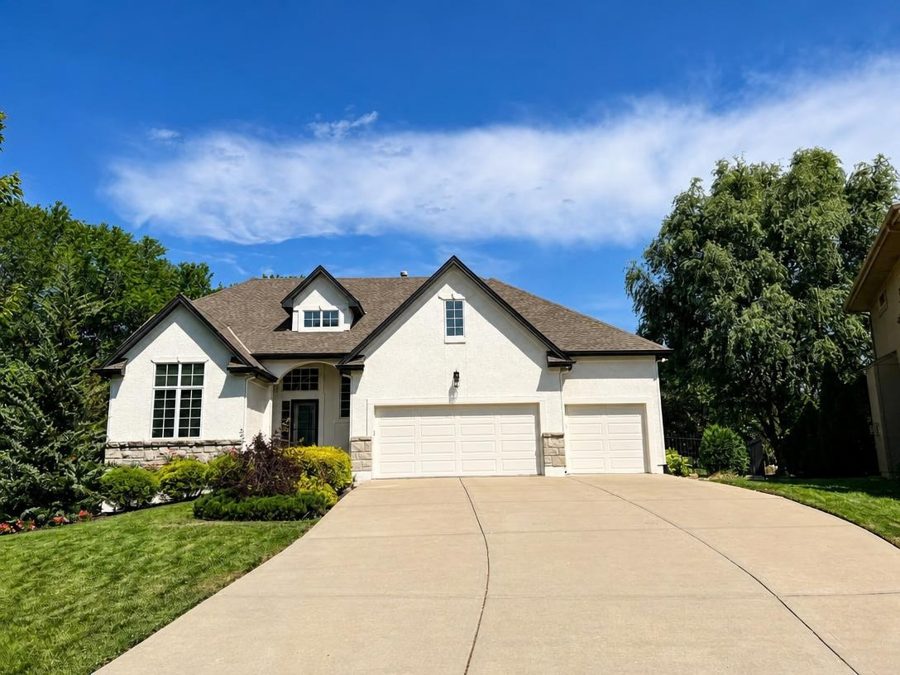 House exterior repainted white with cream garage doors