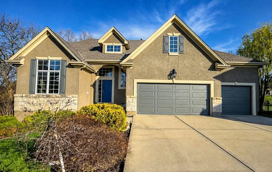 House exterior with brown stucco and gray garage doors
